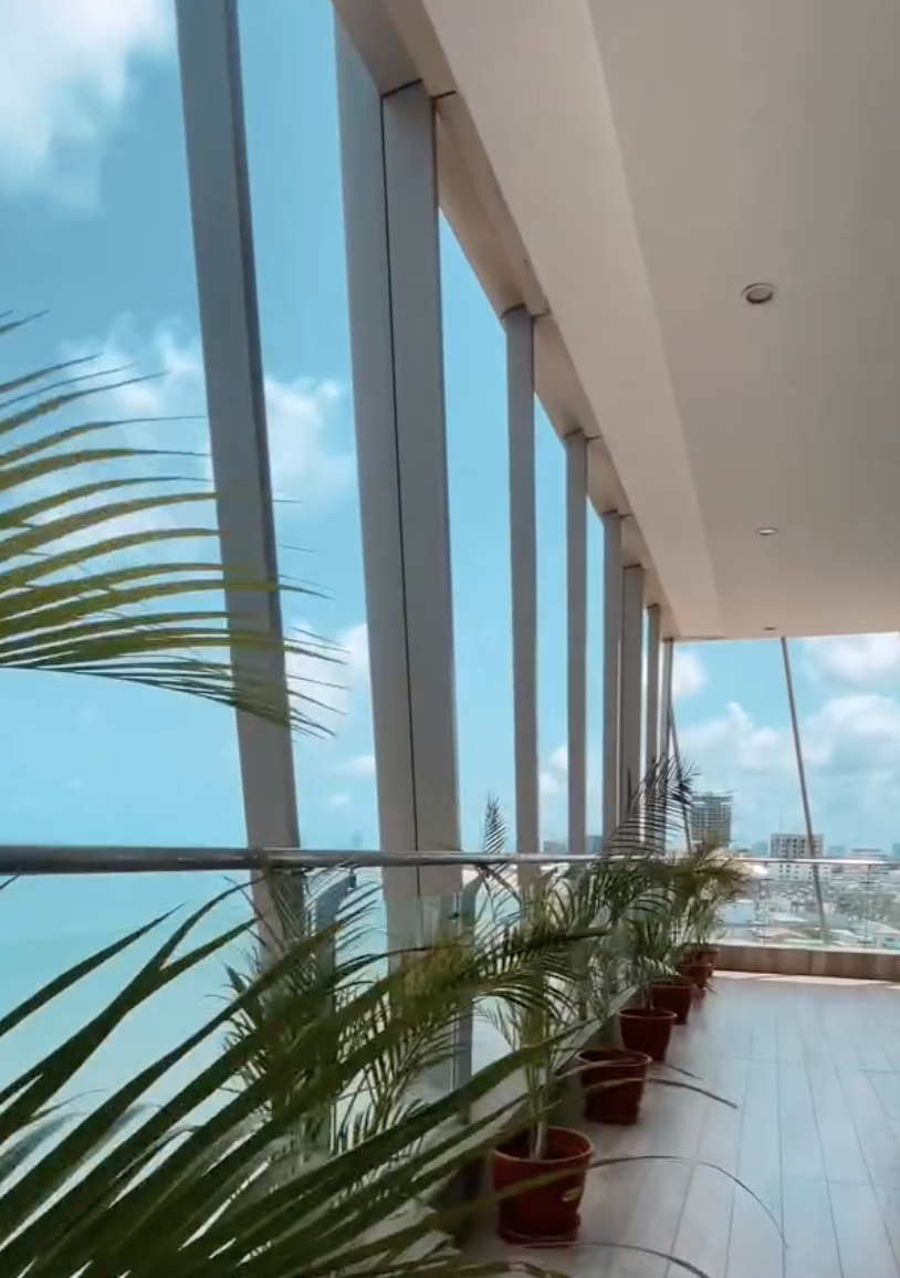 Glass-walled balcony with palms at 788 on the Sea, Lekki